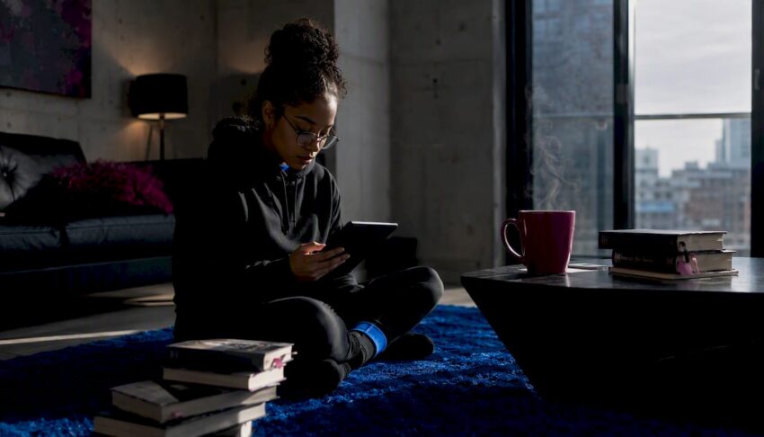 Woman reading Kindle Unlimited on tablet in living room