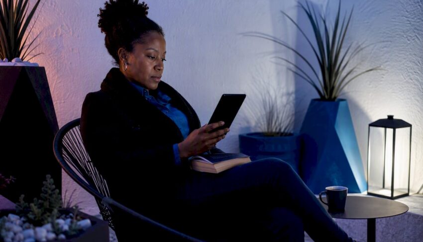 Woman reading Kindle and paperback book