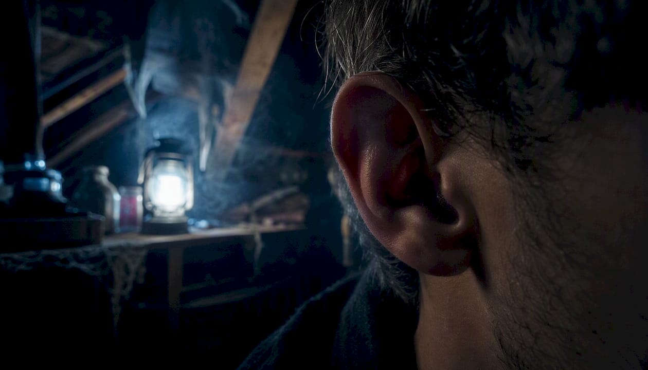 Close-up of ear in dim candlelit room