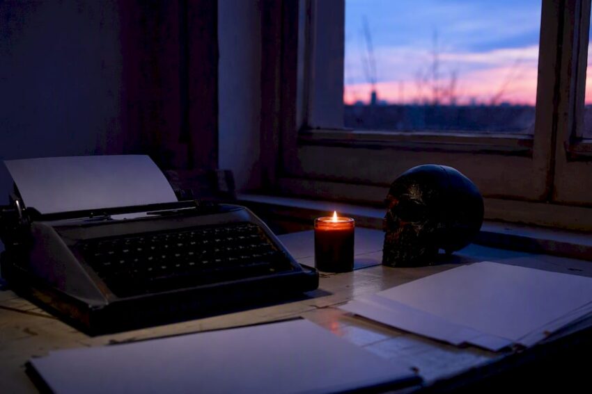 Dim dystopian study with typewriter and skull sculpture