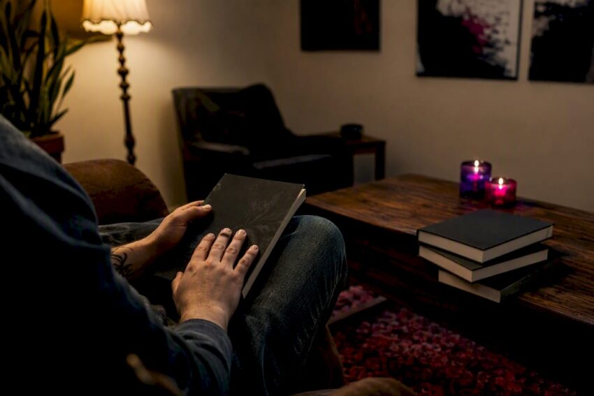Hands closing a dark supernatural fiction book