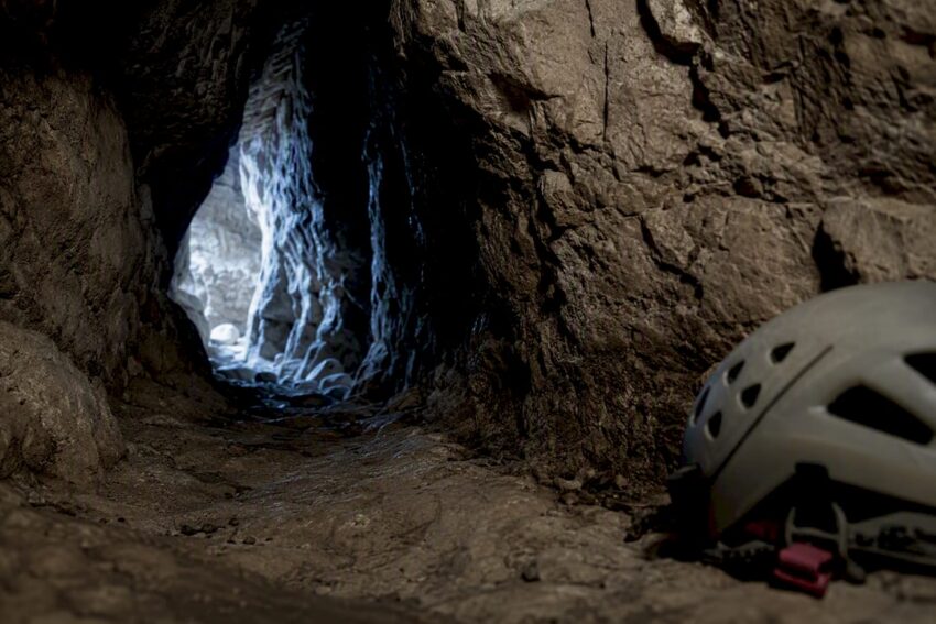 Narrow cave passage fading into darkness