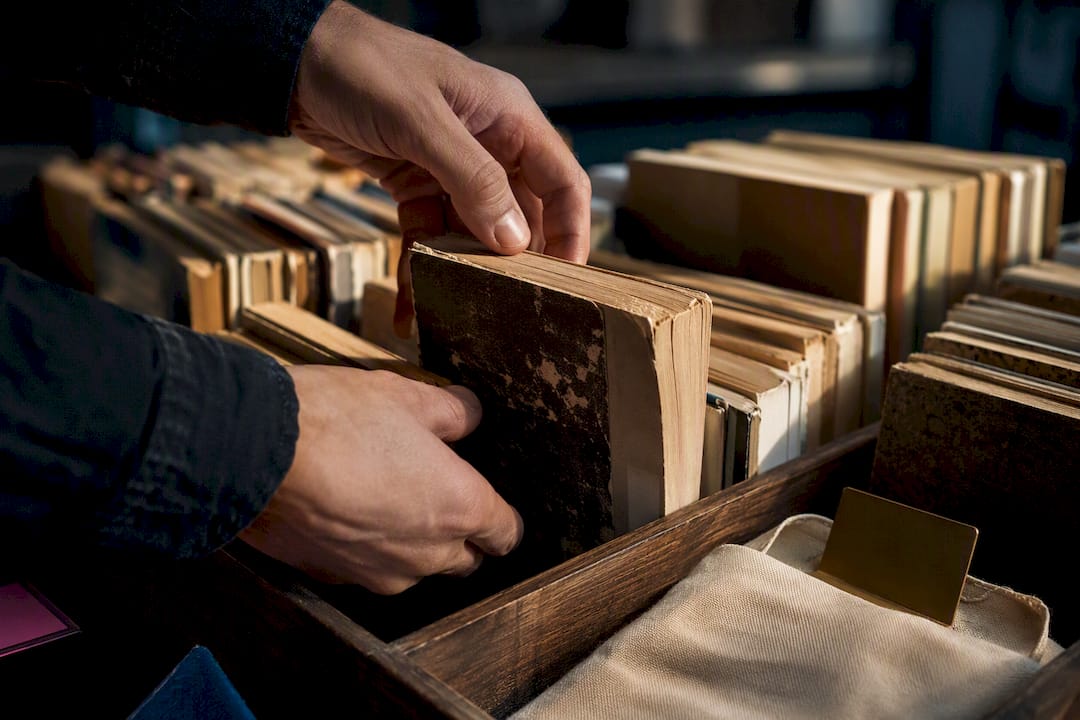 Hands examining worn vintage paperback