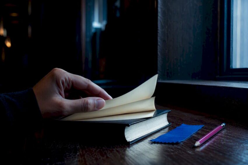 Reader turning page in dark reading alcove