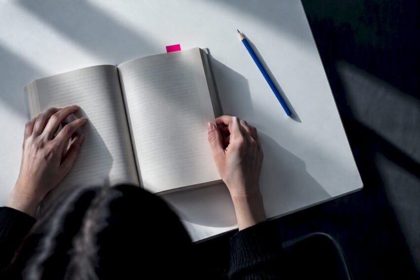 Hands reading an anonymous psychological horror novel